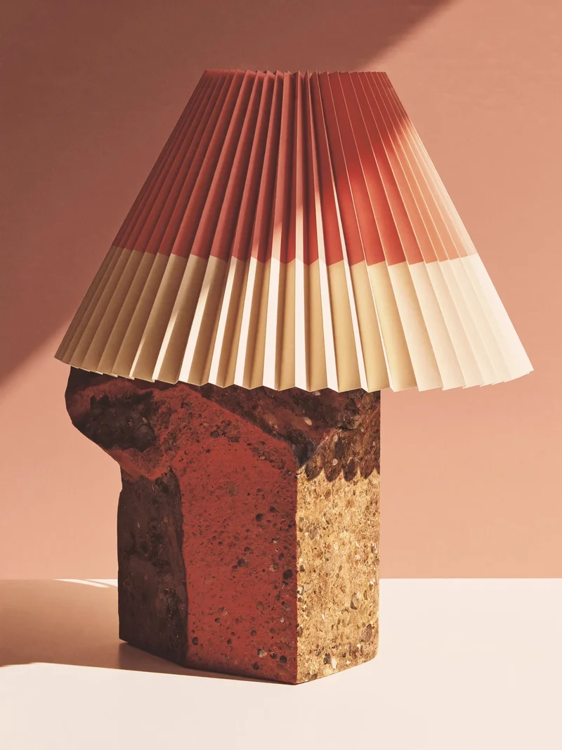 Studio illustrativo di lampada da scrivania plissé con base in pietra